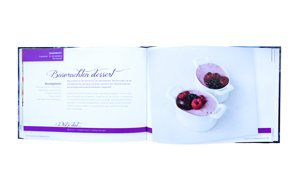 Open boekpagina van Straight away Balanced Food met recept voor bosvruchten dessert en een foto van romig dessert met bessen in witte schaaltjes.