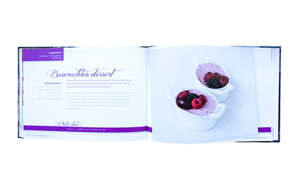 Open boekpagina van Straight away Balanced Food met recept voor bosvruchten dessert en een foto van romig dessert met bessen in witte schaaltjes.